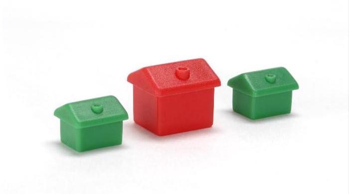 Red plastic miniature-house standing amongst green ones