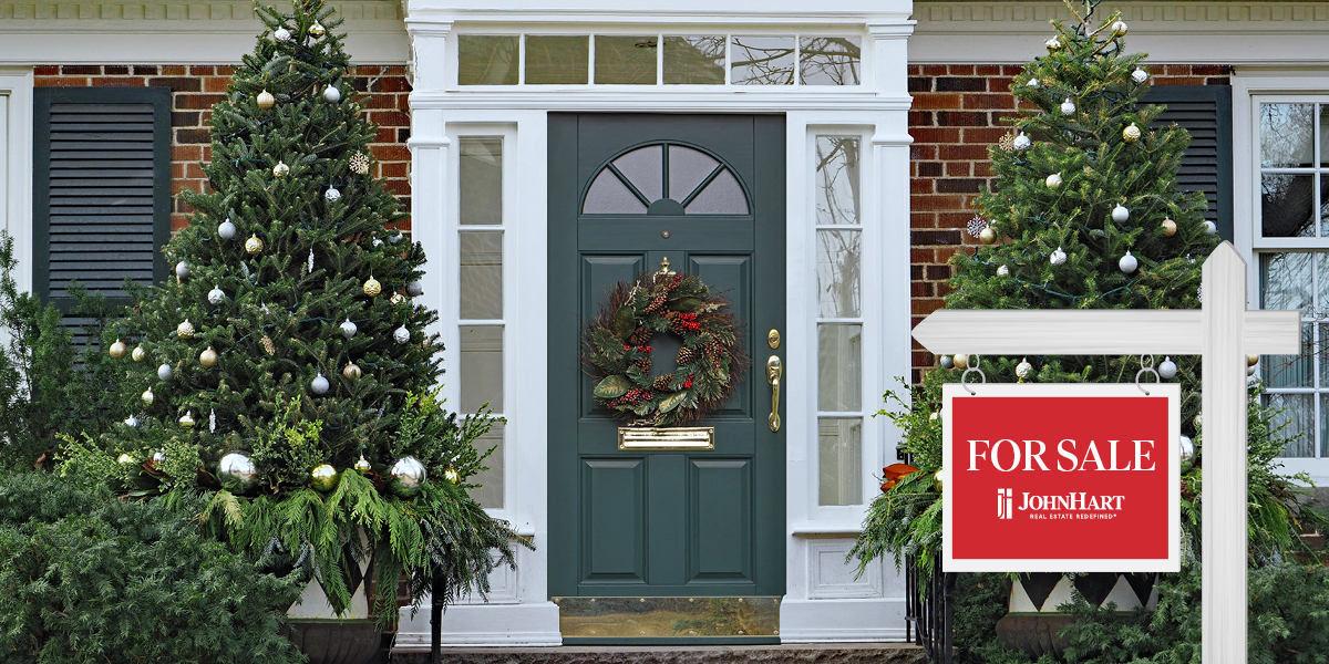 Front door of a JohnHart home for sale, flanked by two decorated Christmas trees