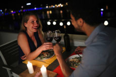 Young beautiful couple in love having romantic dinner at night on rooftop
