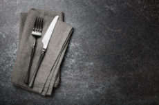 black owned restaurant week in los angeles. Gray background with grey napkin fork and knife