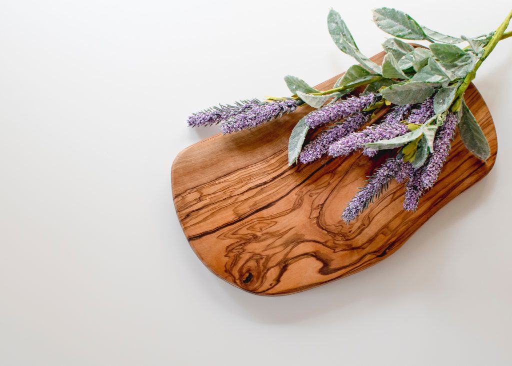 a wooden cutting board with springs of lavender on it