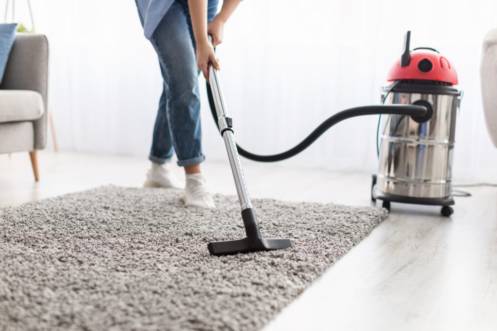 Someone vacuuming their rug for real estate photos