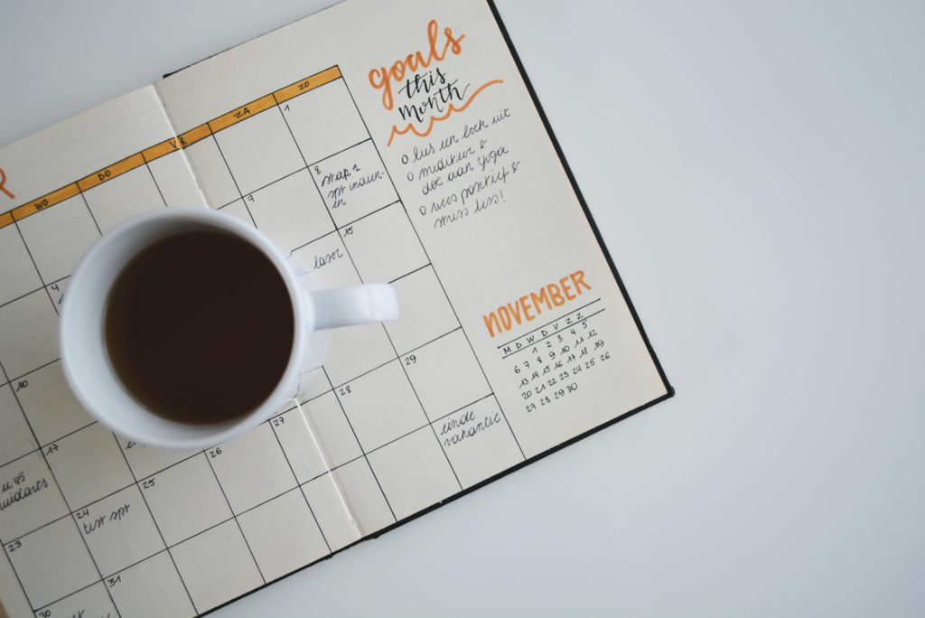 bullet journal with a cup of coffee reading "goals for the month"