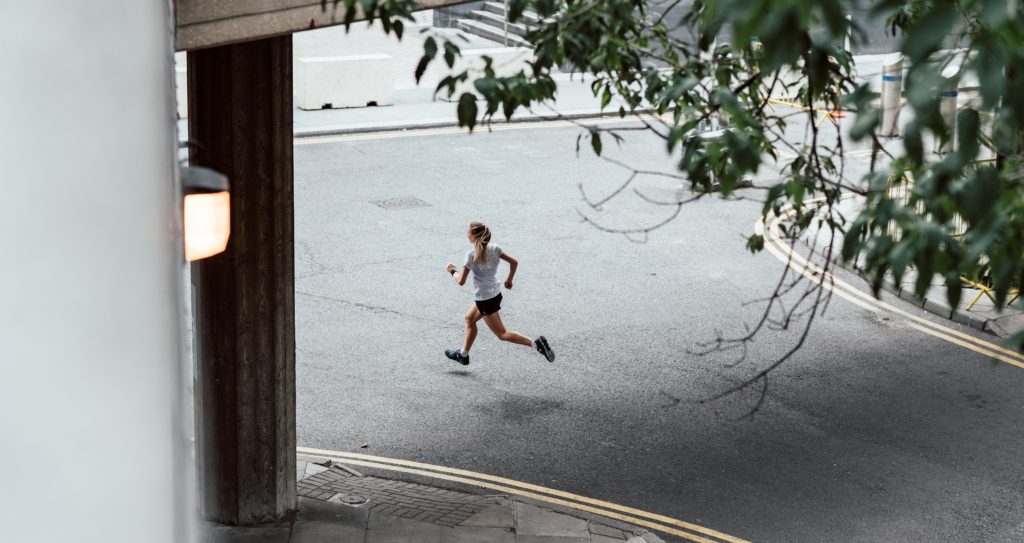 woman running in a neighborhood as a resolution to exercise more