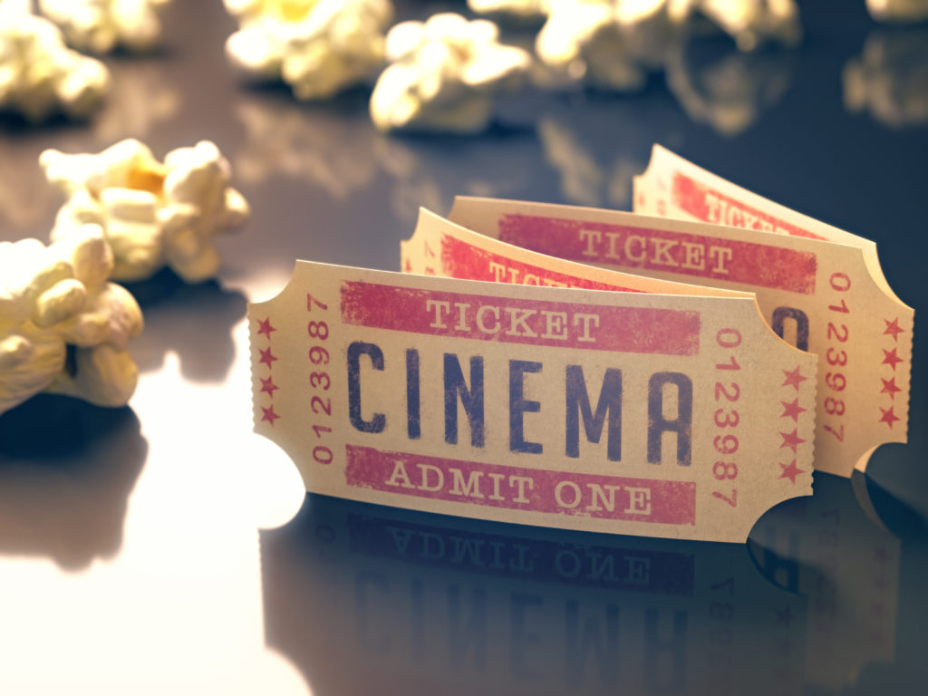 old school ticket stubs for cinema tickets with popcorn sitting in the background