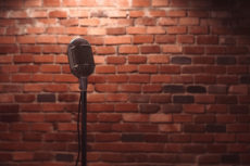 comedy show brick wall empty stage with a black microphone on a stand.