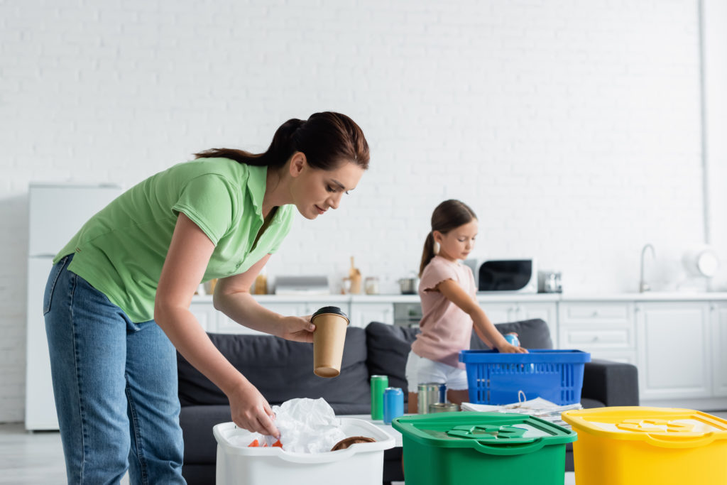 young Caucasian mother and daughter organizing items in various colored bins.